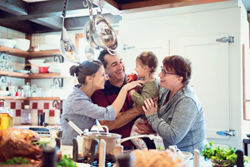 Happy family in kitchen not worrying about their furnace. Reliant Heating & Cooling blog image.